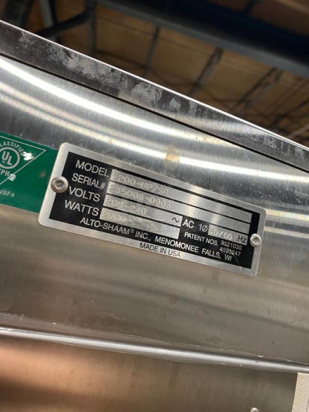 Alto-Shaam 1200-UP/SR stainless steel heated cabinet label with model, serial number, voltage, and watt details.