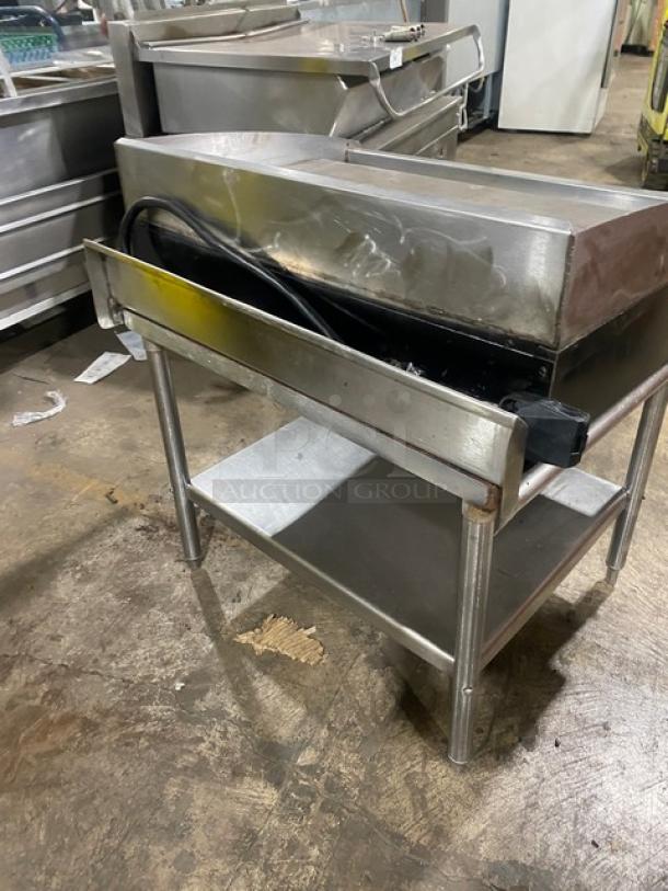 Star commercial stainless steel electric griddle with back and side splash, includes single undershelf equipment stand, on legs.
