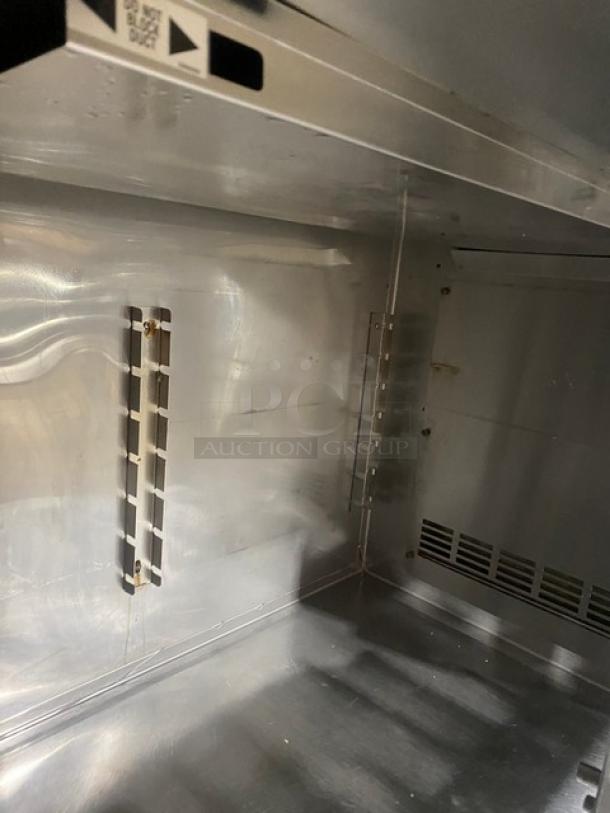 Inside view of Duke Commercial Stainless Steel Refrigerator Model RBC60M, showing shelving brackets and interior condition.