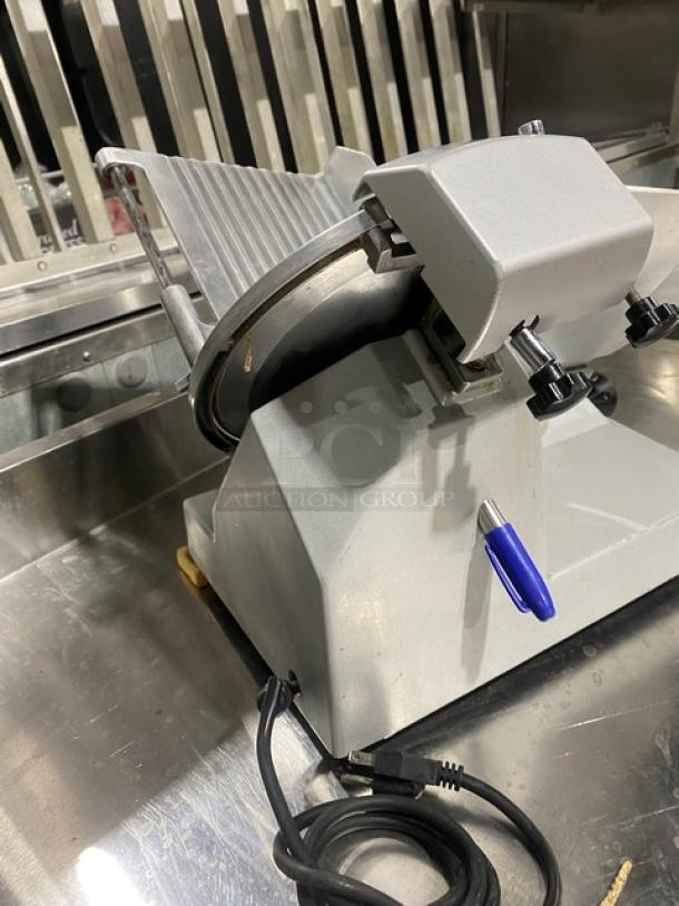 Electric countertop deli meat slicer, steel blade, adjustable thickness, used condition, power cord attached for commercial use.