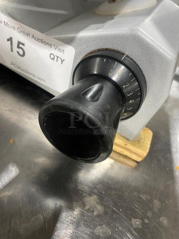 Commercial electric countertop deli meat slicer, adjustable thickness dial, steel body, used condition. Label shows auction info.