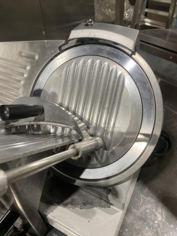 Commercial electric powered countertop deli meat slicer, stainless steel, sturdy construction, clean, excellent condition.