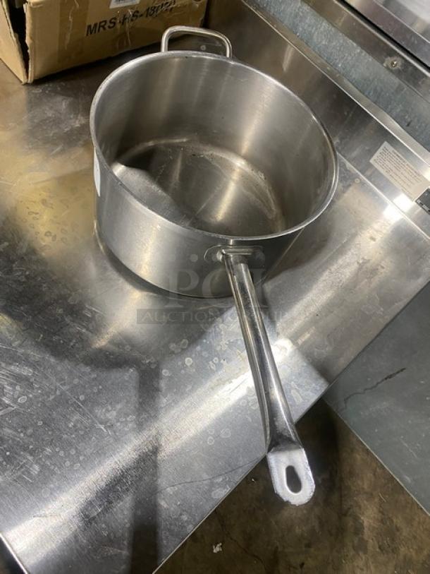 Commercial round sauce pot, stainless steel, with long handle and side grip. Used condition, no visible markings or labels.