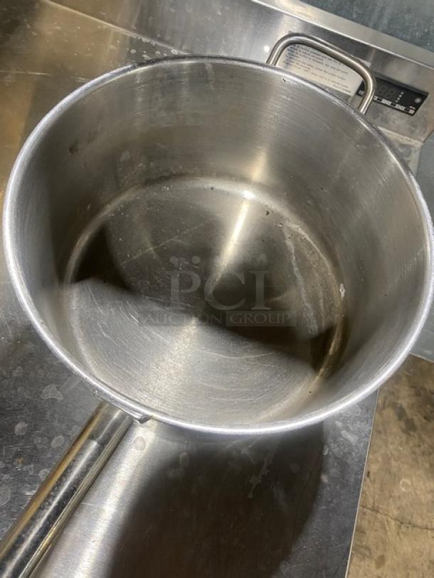 Stainless steel commercial round sauce pot, used condition, with visible handle and capacity markings. Durable kitchenware.