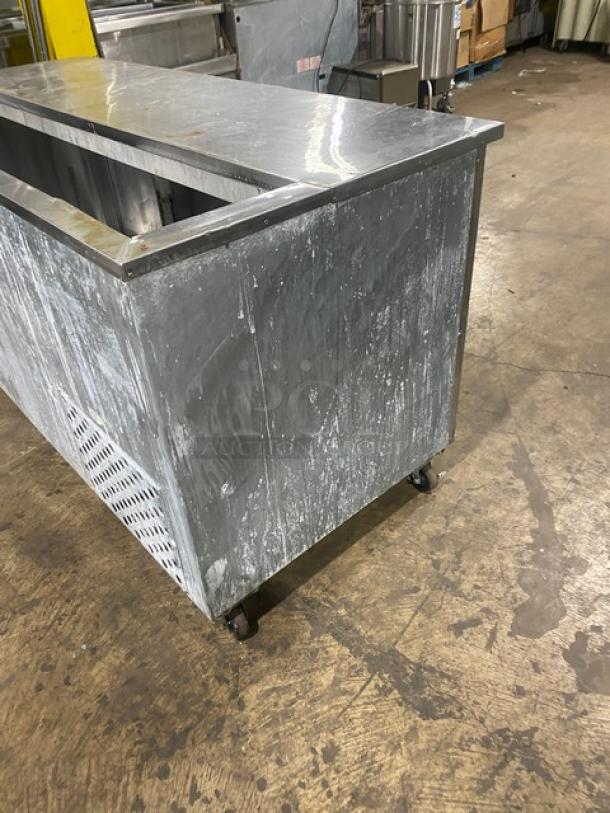 Leader stainless steel 3-door refrigerated prep table on casters, with visible wear. Includes poly-coated wired rack, 115V, 1 phase.