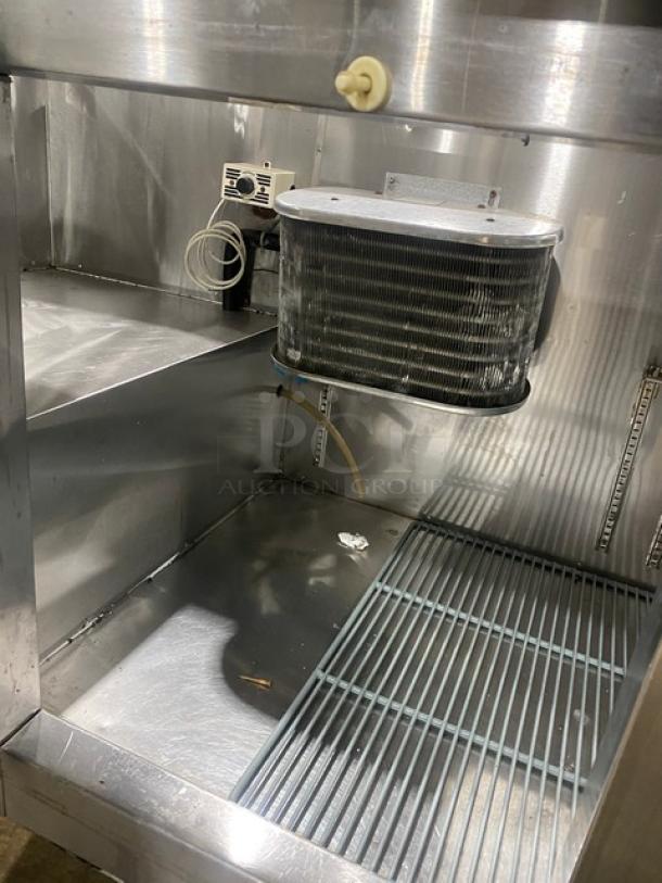 Leader stainless steel 3-door refrigerated prep table with poly-coated wired rack. 115V, 1 phase, on casters, for sandwiches/salads.