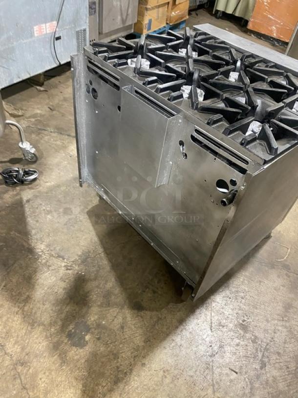 U.S. Range commercial stainless steel 6 burner, natural gas range with enclosed dry cabinet-style base on casters, shown in a kitchen.