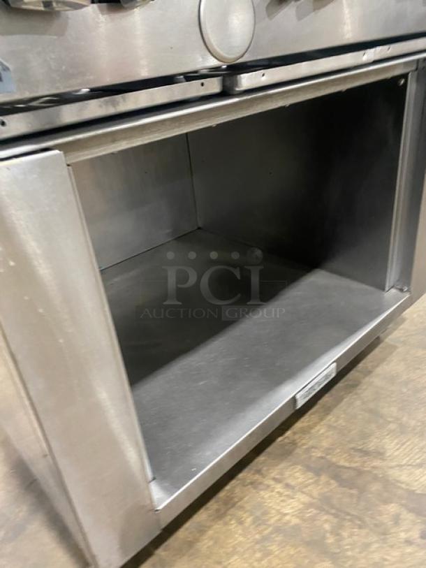 U.S. Range 6-burner commercial stainless steel range, natural gas, with enclosed dry cabinet base, on casters.