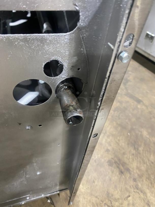 Stainless steel U.S. Range commercial 6-burner with enclosed dry cabinet base, gas connection detail shown, on casters.