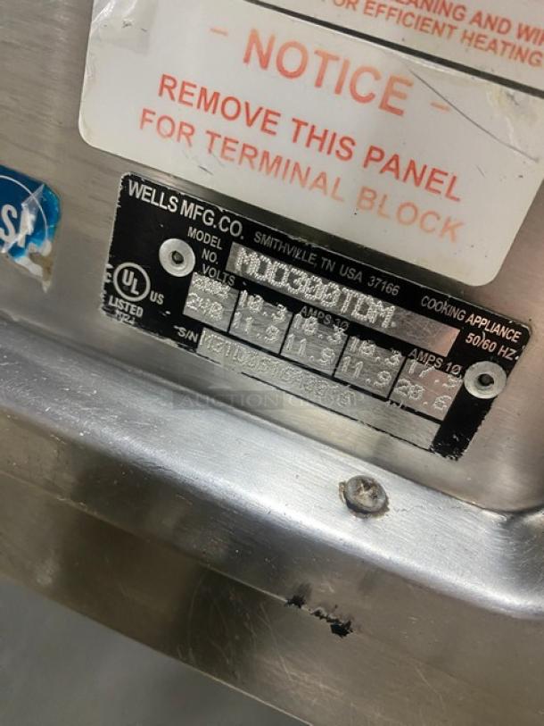 Wells MOD300TDM stainless steel 3-well steam table, 208/240V, with single undershelf. Manufacturer label visible.