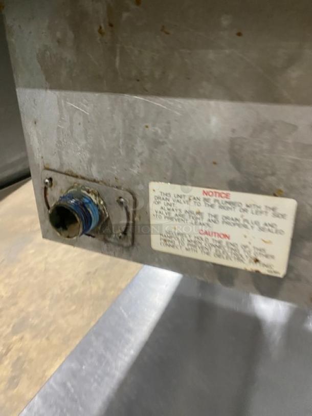 Wells MOD300TDM stainless steel 3-well steamtable. Visible labels with maintenance instructions. Model and serial numbers present.