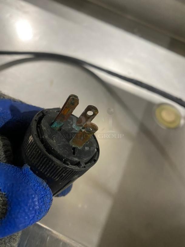 Close-up of a worn electrical plug for the Precision SST2024RTNYC refrigerated cold food bar, showing signs of corrosion.