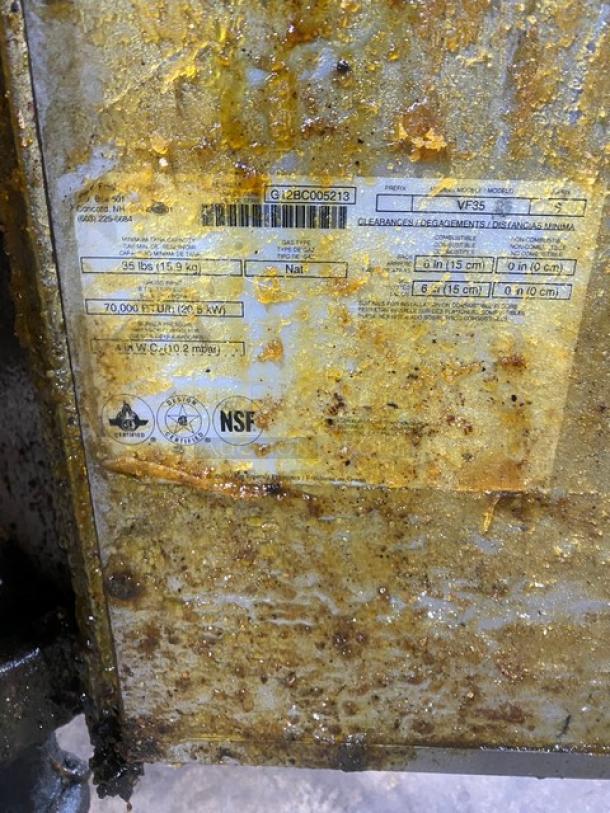 Pitco VF35 stainless steel 35 lb. deep fat fryer on casters. Features a back splash, basket hanger, fry basket, and gas hose. Serial number G12BC005213 visible on label, NSF certified. Used condition.