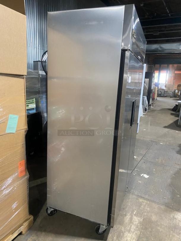 True TM52 commercial stainless steel 2-door reach-in refrigerator on casters. Includes poly-coated wired rack, SN: 1-3107073.