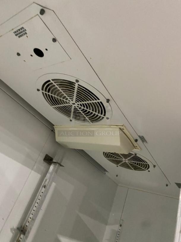 True TM52 commercial stainless steel 2-door reach-in refrigerator interior with ventilated fans and poly-coated wired rack.