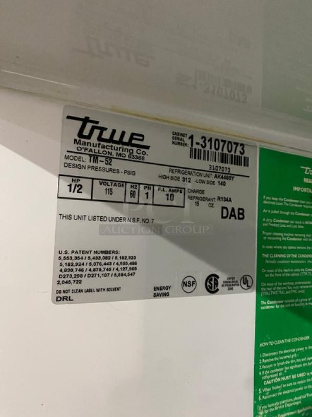 True TM-52 commercial refrigerator tag; 115V, 1-phase, NSF certified, serial number 1-3107073, on casters.