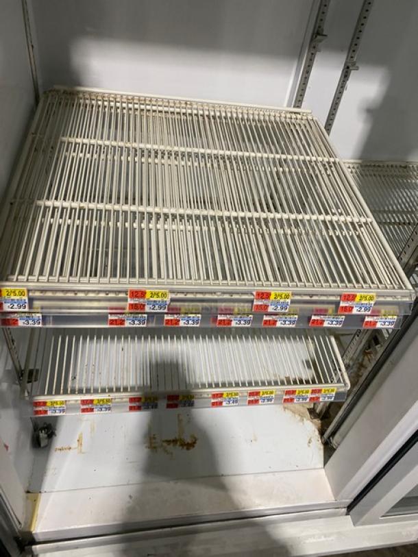 Beverage-Air MT49W commercial refrigerator, glass doors, poly-coated wire racks, visible product pricing labels, used condition.