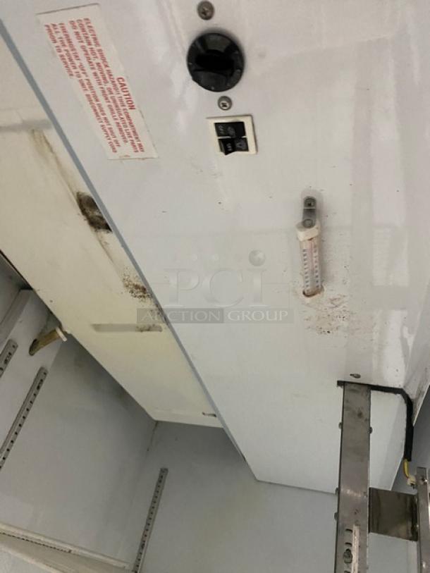 Beverage-Air MT49W commercial fridge interior with poly-coated rack, showing temperature dial and caution label. Some visible wear.