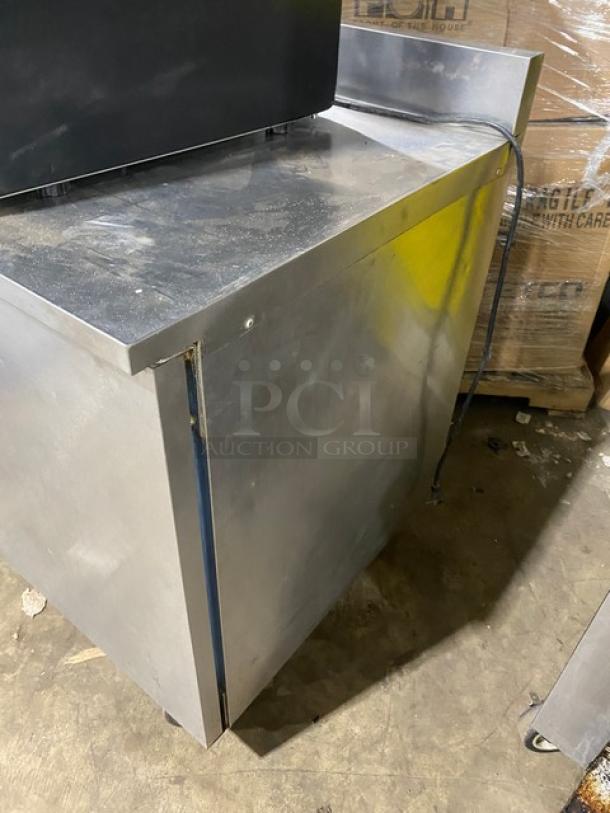 Delfield Enodis Series stainless steel worktop refrigerator, Model 402, single door, upturned backsplash, on casters.