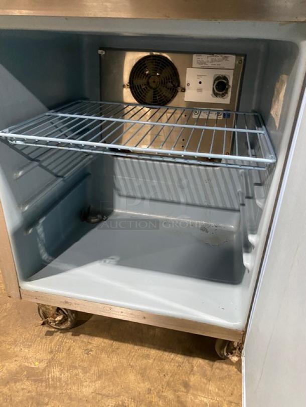 Delfield Enodis Series stainless steel refrigerator, model 402, with upturned backsplash, interior view showing single shelf.