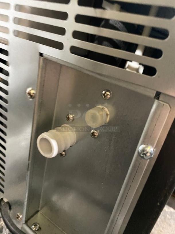 Asbury MIM50P stainless steel ice maker, rear view showing vent and pipe fittings. Energy Star certified, model label visible.