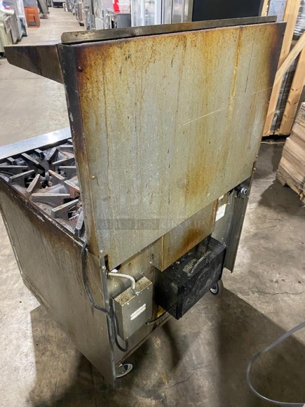 Garland stainless steel 6-burner gas range/oven combo. Features backsplash, overhead salamander shelf, and casters. Used condition.