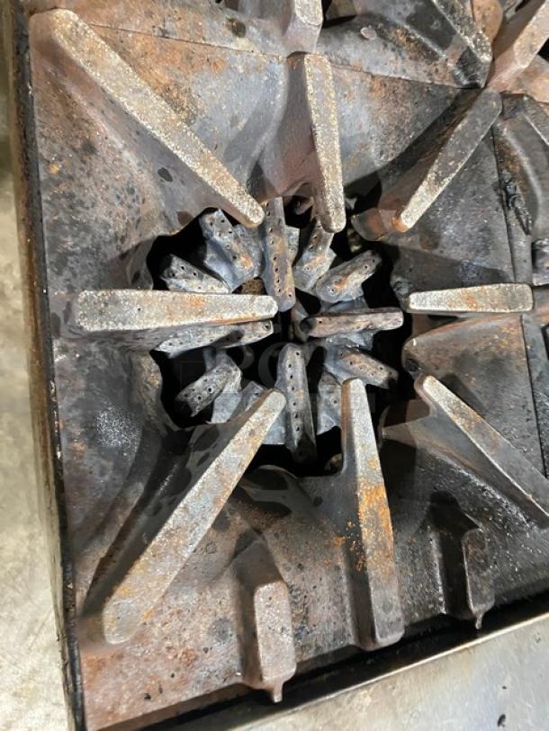 Garland commercial stainless steel 6-burner range top; visible rust and wear on grates.