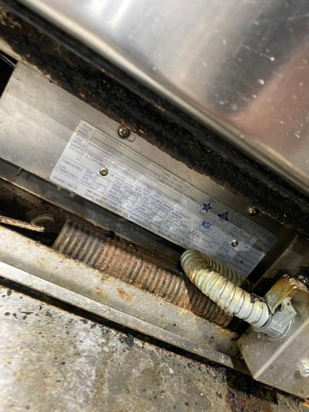 Garland commercial stainless steel gas range/oven combo, 6 burners, overhead salamander shelf, with wired oven rack, on casters.