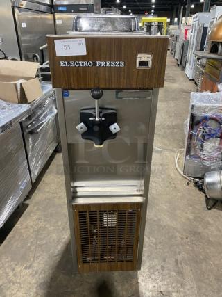 Electro Freeze stainless steel single flavor soft serve machine with wooden-style front, on casters, in used condition.