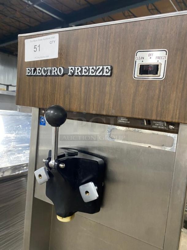 Electro Freeze single flavor soft serve machine, wooden-style panel, stainless steel, electric, on casters, clean/off/freeze switch.