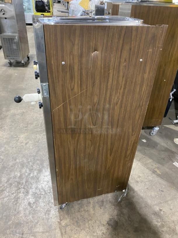 Duke Model 876 single flavor slush machine, wood-style paneling, stainless steel, electric, 115V 1 phase, on casters.