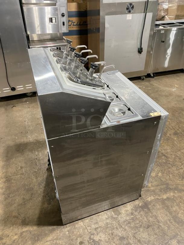 Silver King SKF2A stainless steel refrigerated ice cream topping dispenser with poly-coated wired rack, model SAEC42273A, 115V, used condition.