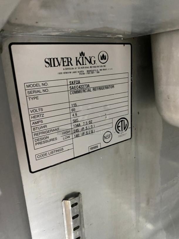Silver King SKF2A stainless steel ice cream topping dispenser with poly-coated rack, model info plate visible.