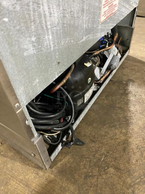 Silver King SKF2A stainless steel ice cream topping dispenser, exposed wiring and components, model and serial labels visible.