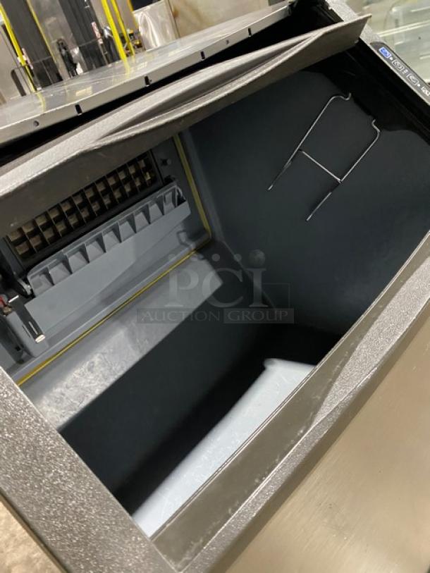 Manitowoc UD0140A stainless steel undercounter ice maker, electric powered, on legs, visible interior, excellent condition.