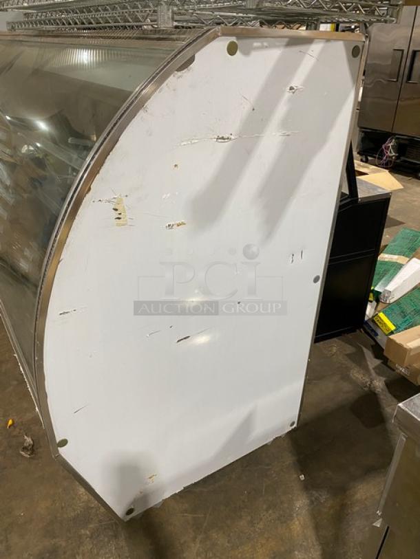 Leader NRHD96 refrigerated deli display case, stainless steel with curved glass, rear sliding doors, minor exterior wear.