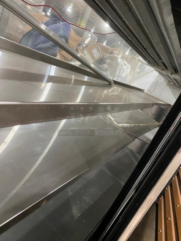 Leader NRHD96 refrigerated merchandiser display case with stainless steel and curved glass. Features rear sliding doors, lower storage.