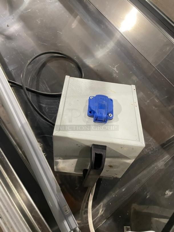 Commercial slanted glass refrigerated display case, black finish, double sliding doors, rear prep area, on casters.