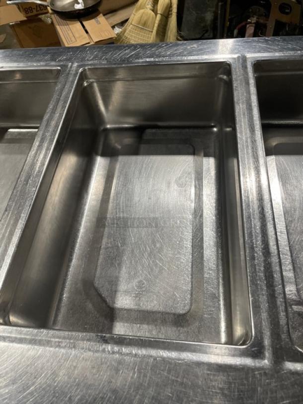 Delfield 18MC68P-EF stainless steel refrigerated salad bar with 5 wells, 4 drawers, enclosed undershelf, on casters.