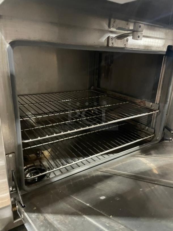 Flame-Mate 3-Compartment Stainless Steel Steam Cabinet, Model ESC3NN, natural gas, on legs, interior view with metal racks.