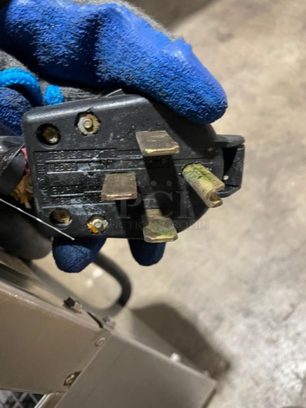 Close-up of an electrical plug for a Keating 14CMBB fryer. The plug shows some wear, indicative of use.