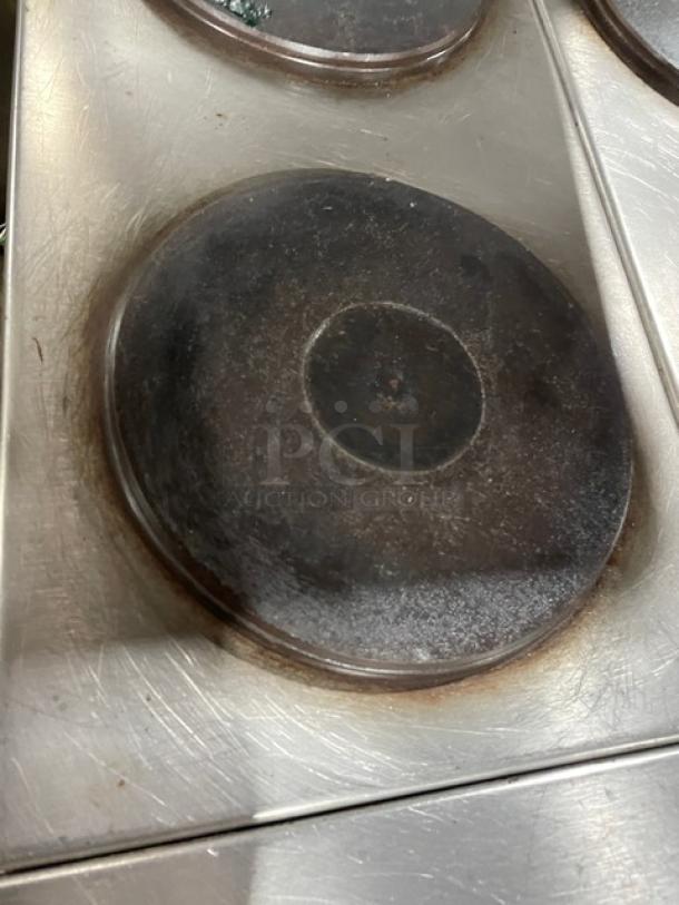 Imperial stainless steel 4-burner hot plate range top, featuring a used burner with visible surface wear.