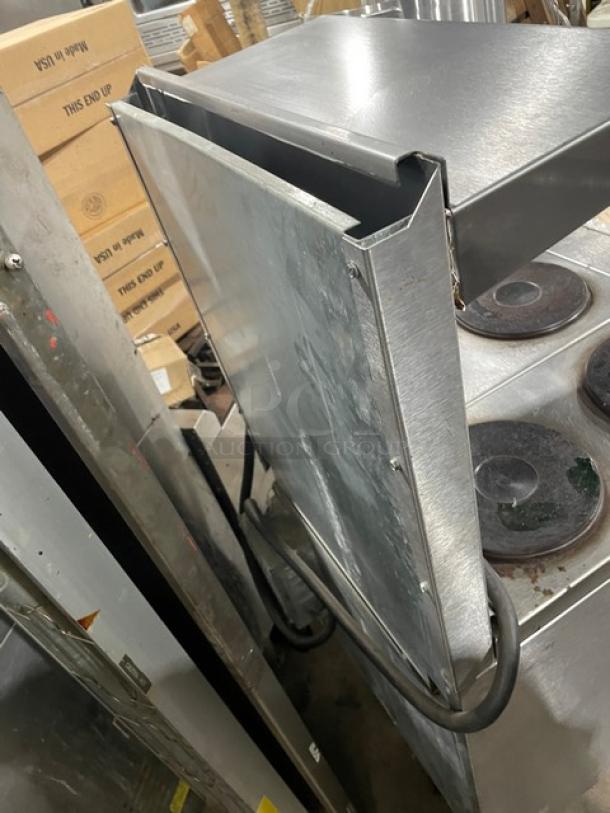 Imperial stainless steel electric 4-burner hot plate range/oven combo with backsplash, overhead salamander shelf, and wire oven rack.