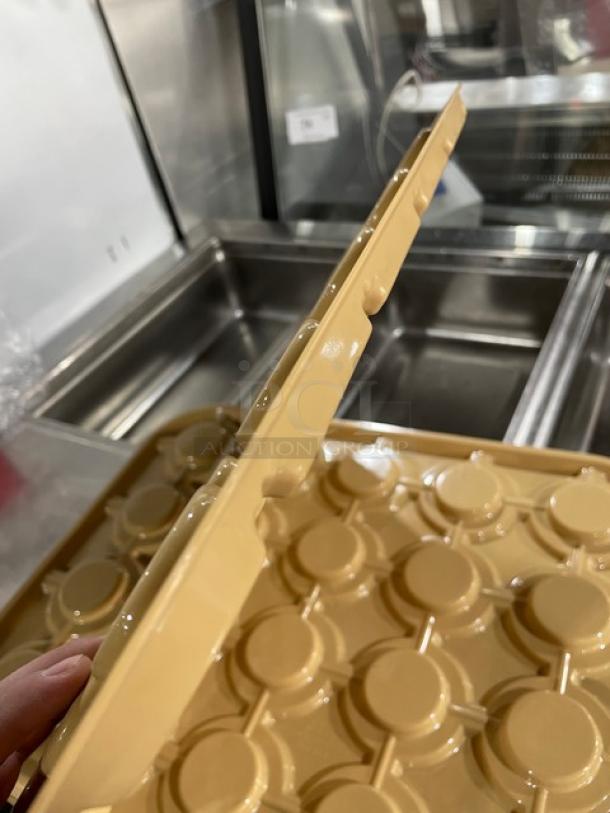 Cambro commercial beige rectangular cup stacker, new condition, features circular grooves for secure stacking, durable plastic.