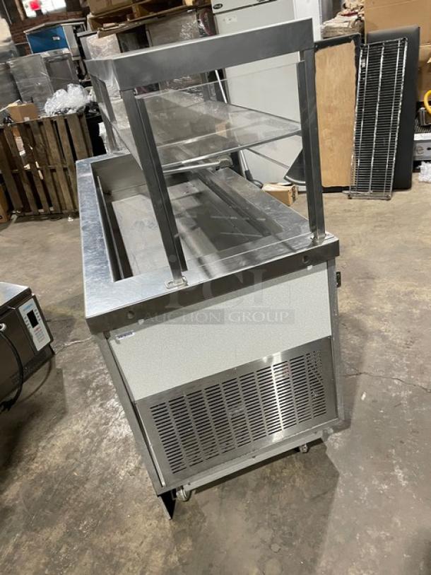 Servolift stainless steel refrigerated salad bar, model 5055RCW, with overhead sneeze guard, cabinet base, on casters.