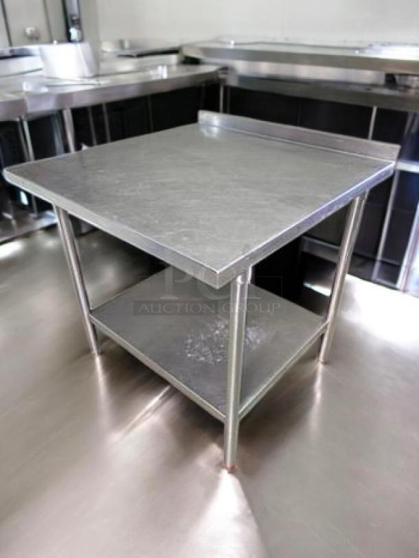 Stainless steel prep table with backsplash, 36”x36”x36”, commercial grade, heavy-duty, fully cleaned and ready for use.