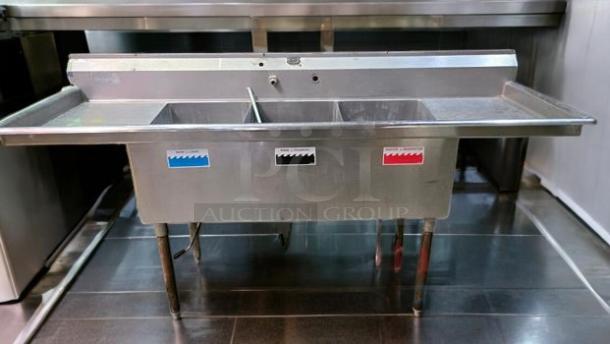 Stainless steel 3-compartment sink, faucet cutout, electrical access, side drainboards, 84"W x 27"D x 44"H, excellent condition.