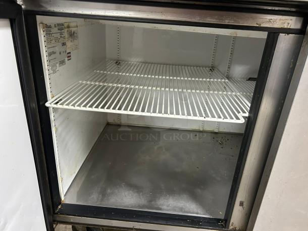 True TPP-AT2-93-HC pizza prep table interior, white wire shelves, stainless steel base, visible label with model details.