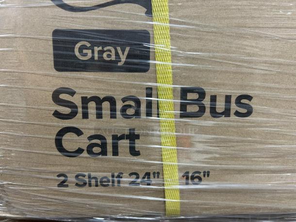 Brand new Choice small bus cart, 2-shelf, 24" x 16", gray, still in packaging with visible label and yellow strap.