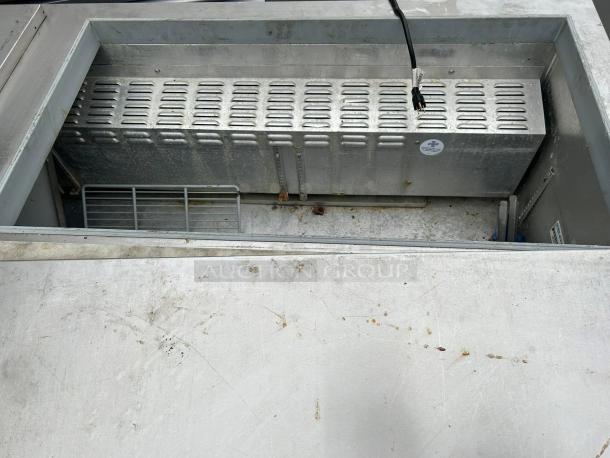 Continental SW72N30M-FB 72" 3-door refrigerated prep table, excellent condition, visible interior with power cord.